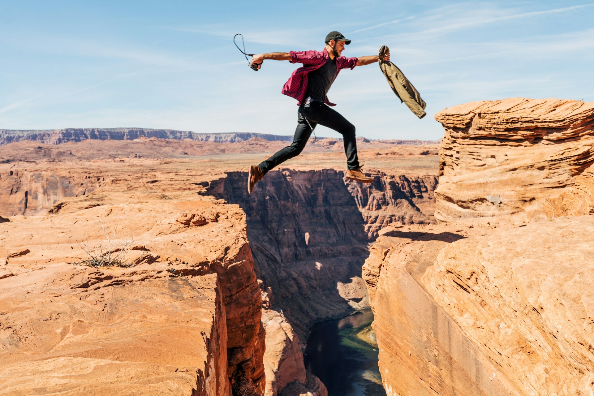A person taking a leap of faith across a wide canyon, symbolizing the risks and challenges of a modern career change.